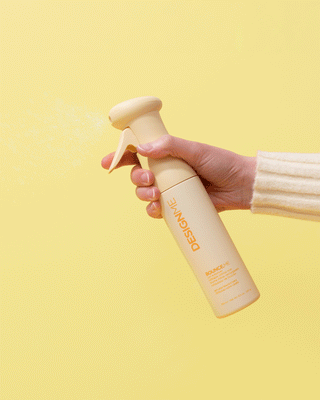 Dynamic image of a hand misting BOUNCE.ME Curl Enhancer Mist, highlighting the spray in action.