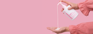 Hand dispensing PUFF.ME volumizing conditioner from pump bottle against a pink background