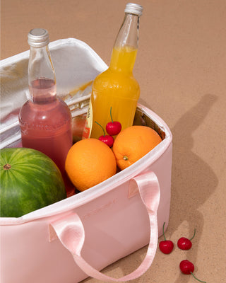 Forever salty beach cooler full of fruits and drinks on the beach.