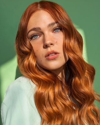 Model using GLOSS.ME Hair Oil to enhance shine and smoothness in soft, healthy-looking hair