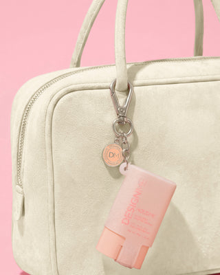 HOLD.ME styling stick glitter pouch keychain hanging on purse.